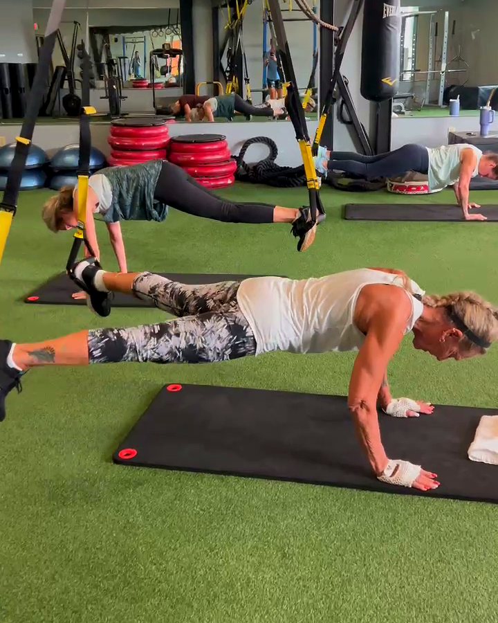 Members holding suspended planks in a VIVE Arena TRX class