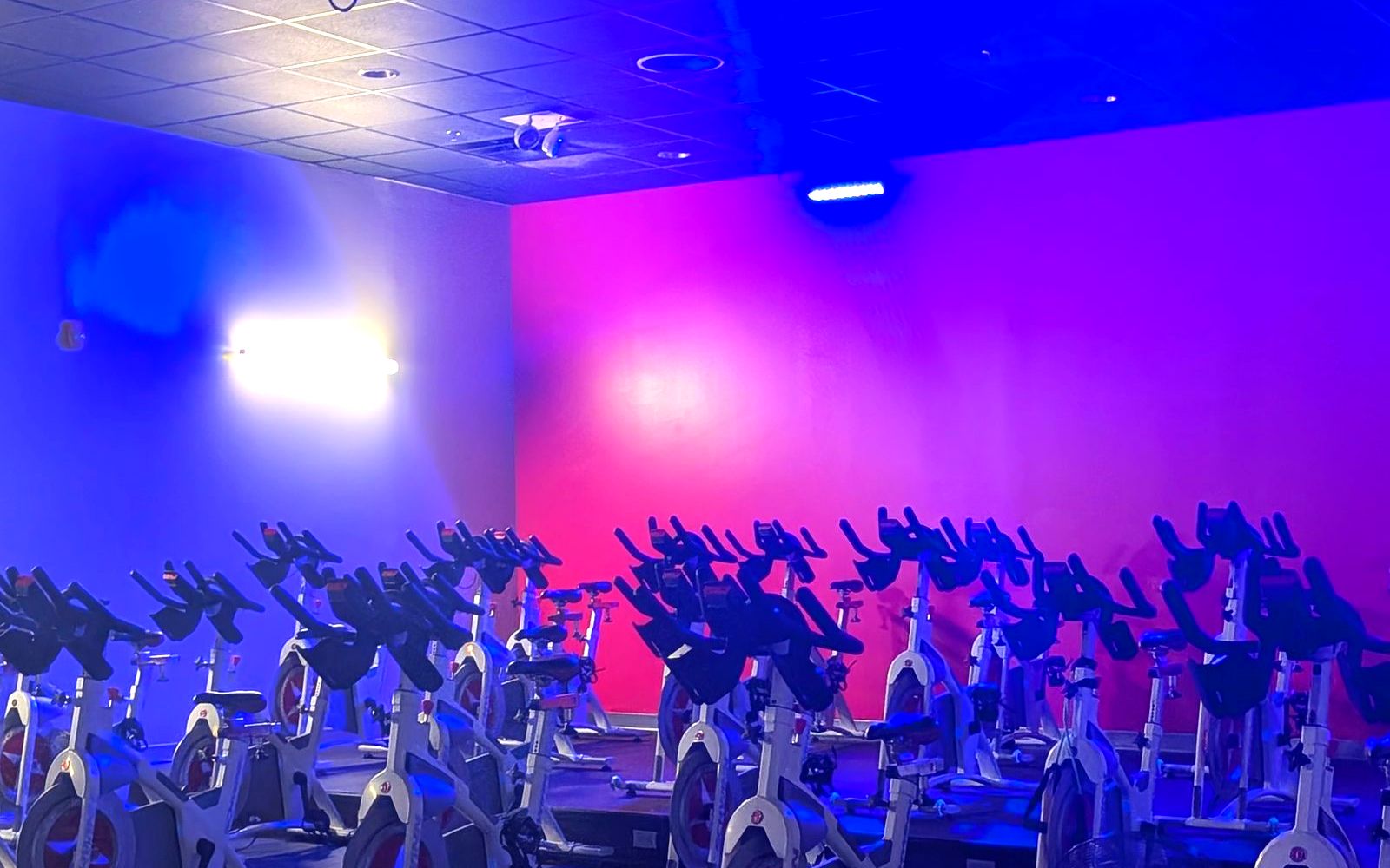 The VIVE cycle studio lit up during a group fitness class in Kingston, PA