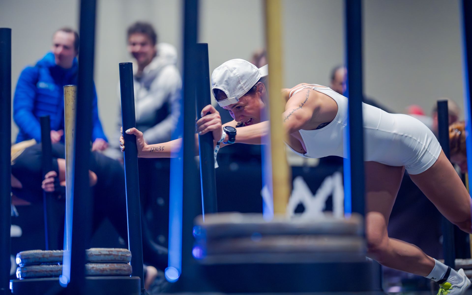 An athlete driving a weighted sled down the track at a HYROX race